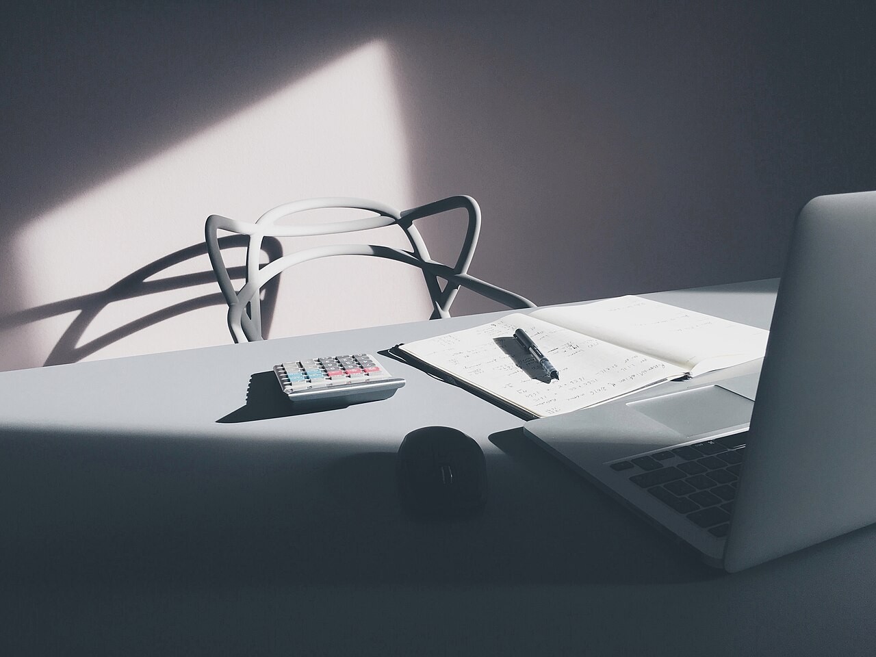 Mesa com notebook, calculadora e documentos