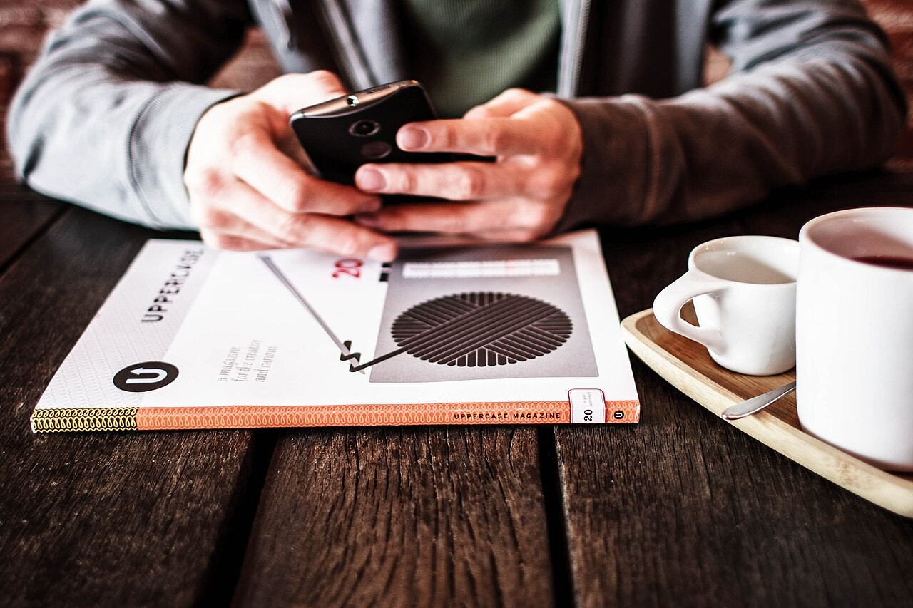 Celular sobre material de leitura em uma mesa